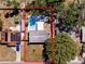 Overhead view of the property, defined by red lines, featuring the pool, backyard, house, and surrounding landscape at 8829 93Rd St, Seminole, FL 33777