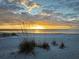Scenic beach view at sunset featuring sand dunes and golden light reflecting on the water's edge at 8829 93Rd St, Seminole, FL 33777