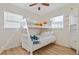 Bright bedroom with bunk beds, wood floors, and a built-in cabinet for storing toys and books at 8829 93Rd St, Seminole, FL 33777