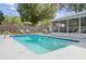 Large backyard pool area with lounge chairs, privacy fence, and screened-in porch at 8829 93Rd St, Seminole, FL 33777