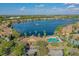 An aerial view of homes surrounding a lake with a fountain and a community pool and clubhouse at 9118 Lake Chase Island Way # 9118, Tampa, FL 33626