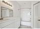 Bright bathroom with white vanity, framed mirror, tub, and shower with a curved shower rod at 9118 Lake Chase Island Way # 9118, Tampa, FL 33626