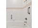 Bright bathroom featuring a white tiled shower and tub with handrails at 9118 Lake Chase Island Way # 9118, Tampa, FL 33626