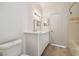 Bright bathroom featuring a white vanity with double lights and wood-look flooring at 9118 Lake Chase Island Way # 9118, Tampa, FL 33626
