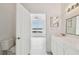 Bathroom leading to bedroom, featuring a modern vanity with a sink, mirror, and toilet at 9118 Lake Chase Island Way # 9118, Tampa, FL 33626