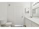 Modern bathroom featuring a toilet, a vanity with mirror and lighting, and a door to the hallway at 9118 Lake Chase Island Way # 9118, Tampa, FL 33626
