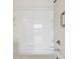 Close-up of a white tiled shower and tub with chrome fixtures and safety bar in the all-white bathroom at 9118 Lake Chase Island Way # 9118, Tampa, FL 33626
