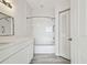 All-white bathroom featuring a vanity, toilet, tub with shower, and neutral gray wood-look floors at 9118 Lake Chase Island Way # 9118, Tampa, FL 33626
