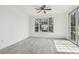 Bright room with hardwood floors, ceiling fan, and a large window view at 9118 Lake Chase Island Way # 9118, Tampa, FL 33626