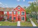 Lovely red townhome with decorative shutters, lush lawn, and welcoming entrance framed by mature trees at 9118 Lake Chase Island Way # 9118, Tampa, FL 33626