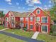 Inviting red townhome featuring detailed architecture, manicured landscaping, and a cozy entryway under blue skies at 9118 Lake Chase Island Way # 9118, Tampa, FL 33626