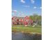 Eye-level view of red townhome with manicured lawn and walkway at 9118 Lake Chase Island Way # 9118, Tampa, FL 33626