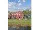Exterior of a red townhome with a tidy front lawn at 9118 Lake Chase Island Way # 9118, Tampa, FL 33626