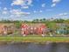 Waterfront townhomes featuring colorful exteriors, mature landscaping, and community walkways at 9118 Lake Chase Island Way # 9118, Tampa, FL 33626