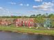 Townhomes with vibrant exteriors, a walking path, and a lake view at 9118 Lake Chase Island Way # 9118, Tampa, FL 33626