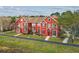 Charming red townhouse with well-kept lawn, trimmed bushes and decorative shutters, bathed in sunlight at 9118 Lake Chase Island Way # 9118, Tampa, FL 33626