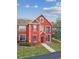 Exterior of a red townhome featuring decorative windows and a well-kept lawn at 9118 Lake Chase Island Way # 9118, Tampa, FL 33626