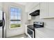 Updated kitchen featuring stainless steel appliances, white cabinets, and a large window with a scenic view at 9118 Lake Chase Island Way # 9118, Tampa, FL 33626