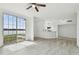 Bright and spacious living room featuring wood-look tile flooring and a view of the lake at 9118 Lake Chase Island Way # 9118, Tampa, FL 33626
