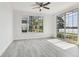 Well-lit living room featuring hardwood flooring, ceiling fan, and large glass sliding door at 9118 Lake Chase Island Way # 9118, Tampa, FL 33626