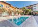 Community pool surrounded by attractive landscaping and colorful buildings on a sunny day at 100 4Th S Ave # 220, St Petersburg, FL 33701