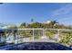 Balcony view showcasing the surrounding lush greenery and a glimpse of the pool area at 103 Morgan Dr, Belleair Beach, FL 33786