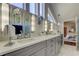 Elegant bathroom featuring dual sinks, vanity lighting, and marble floors at 103 Morgan Dr, Belleair Beach, FL 33786