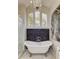 Bright bathroom with a freestanding tub, walk-in shower, stylish chandelier and statement artwork at 103 Morgan Dr, Belleair Beach, FL 33786