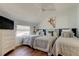 Charming bedroom featuring three twin beds, hardwood floors, and playful giraffe-themed artwork at 103 Morgan Dr, Belleair Beach, FL 33786