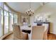 Bright dining room featuring hardwood floors, an elegant chandelier, an artistic painting, and six chairs at 103 Morgan Dr, Belleair Beach, FL 33786
