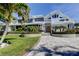 Stunning two-story home with manicured landscaping and a brick driveway, enhancing its curb appeal at 103 Morgan Dr, Belleair Beach, FL 33786