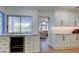 Bright kitchen featuring white cabinetry, an elegant wine refrigerator, and a peek into the living room at 103 Morgan Dr, Belleair Beach, FL 33786