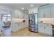 Bright kitchen featuring white cabinets, stainless steel appliances, and a seamless transition into the living area at 103 Morgan Dr, Belleair Beach, FL 33786