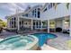 Back exterior view of the property showcasing the pool, hot tub, outdoor entertaining area, and balconies at 103 Morgan Dr, Belleair Beach, FL 33786