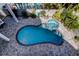 Aerial view of a private pool and hot tub surrounded by a beautifully paved patio at 103 Morgan Dr, Belleair Beach, FL 33786