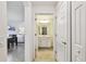 Hallway view leading to a bathroom and living area with neutral paint and tile floors at 1030 Tidewater Shores Loop # 104, Bradenton, FL 34208