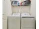 Functional laundry room with washer, dryer, and shelf, offering convenient laundry solutions at 1030 Tidewater Shores Loop # 104, Bradenton, FL 34208
