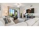 Inviting living room with comfortable seating, a large TV, and serene water views from the balcony at 1030 Tidewater Shores Loop # 104, Bradenton, FL 34208