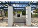 Inviting outdoor kitchen with built-in grill, fireplace, seating, and overhead pergola for shaded dining and entertaining at 1030 Tidewater Shores Loop # 104, Bradenton, FL 34208