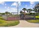 Charming playground with swings and a wooden playset, enclosed by a secure metal fence on a grassy area at 1030 Tidewater Shores Loop # 104, Bradenton, FL 34208