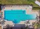 Aerial view of swimming pool with tanning ledge and steps plus lounge chairs and umbrellas at 1030 Tidewater Shores Loop # 104, Bradenton, FL 34208