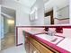 Pink bathroom with tile and vintage-style cabinets at 10754 63Rd Ave, Seminole, FL 33772