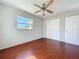 Bedroom featuring hardwood floors, ceiling fan, closet, and a window at 10754 63Rd Ave, Seminole, FL 33772