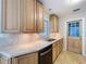 Kitchen features wood cabinets, countertop lights, updated countertops, tile floors and a view of the yard at 10754 63Rd Ave, Seminole, FL 33772