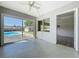 Bright sun room features a ceiling fan, large sliding glass doors to a pool, and polished terrazzo flooring at 10754 63Rd Ave, Seminole, FL 33772