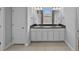 Bathroom featuring double vanity with dark countertop, framed mirrors, and tile flooring at 11503 Quiet Forest Dr, Tampa, FL 33635