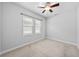 Simple bedroom featuring neutral carpet, ceiling fan and windows with blinds at 11503 Quiet Forest Dr, Tampa, FL 33635