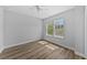 Bright bedroom with hardwood floors, natural light from two large windows, and a ceiling fan at 11503 Quiet Forest Dr, Tampa, FL 33635