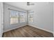 Bedroom featuring laminate wood flooring, neutral walls, and two sunny windows at 11503 Quiet Forest Dr, Tampa, FL 33635
