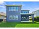 Back exterior view of a two-story home with large windows and a covered patio at 11503 Quiet Forest Dr, Tampa, FL 33635